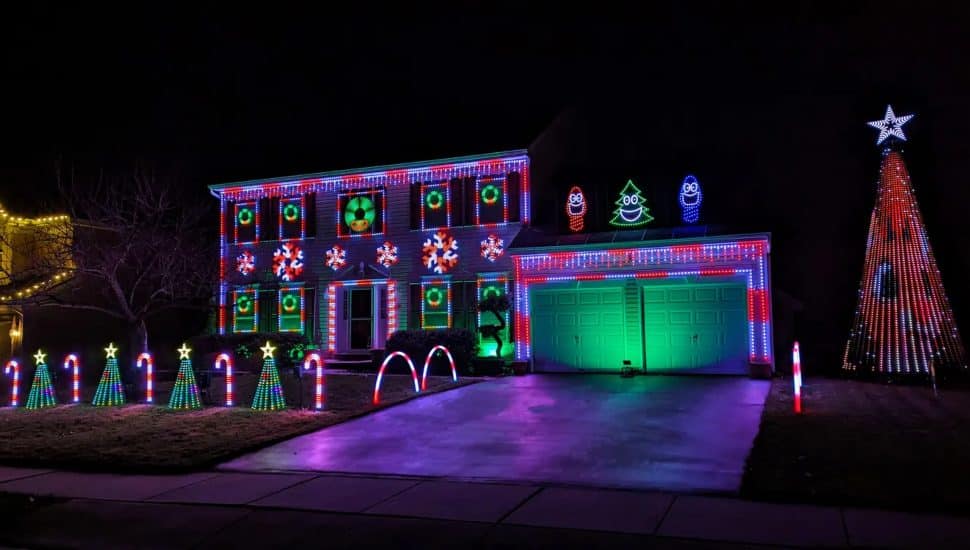 A property lit up with holiday lights at night. Green Heather lights.