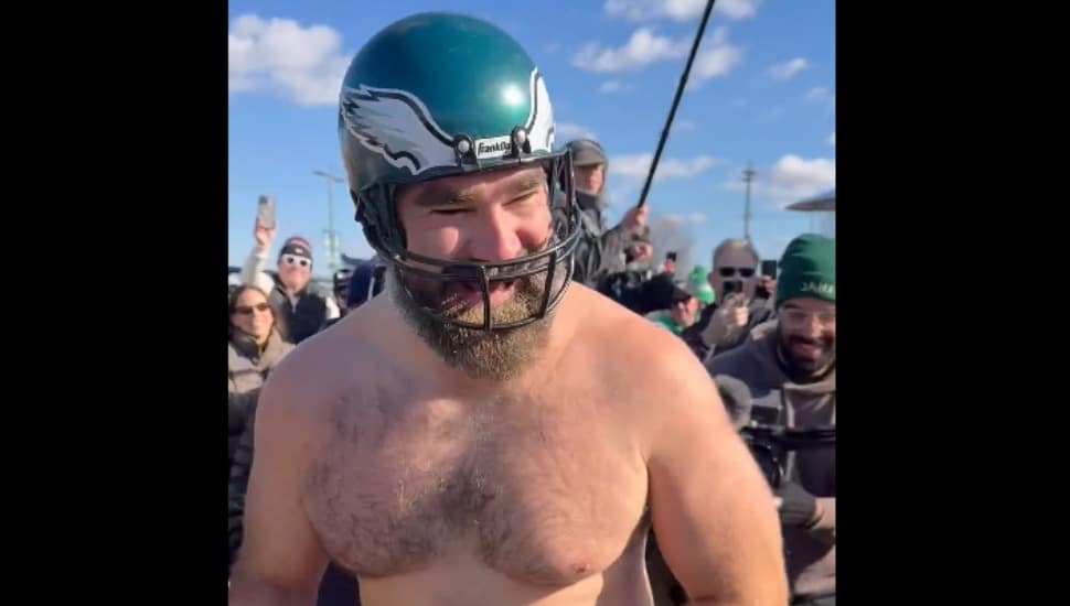 A shirtless Jason Kelce donning a toy Eagles helmet.