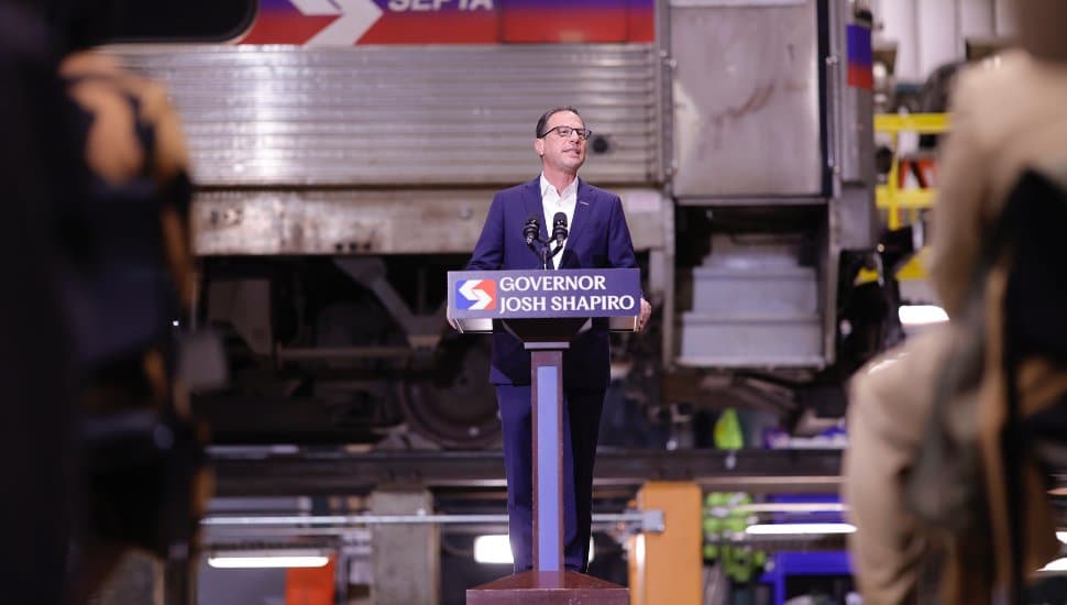 Gov. Josh Shapiro speaks behind a podium at the Frazer Shop and Rail Yard.