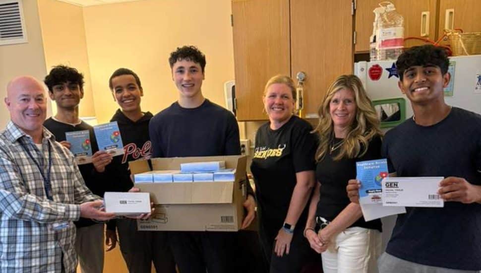 Members of Kind Koala hold boxes of supplies.