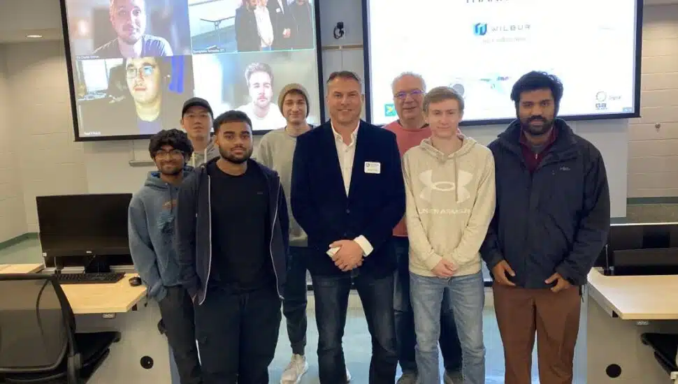 Jason Reed, president of the Digital Solutions Group and GATES Wilmington at GA Telesis LLC, stands with Penn State Brandywine students.