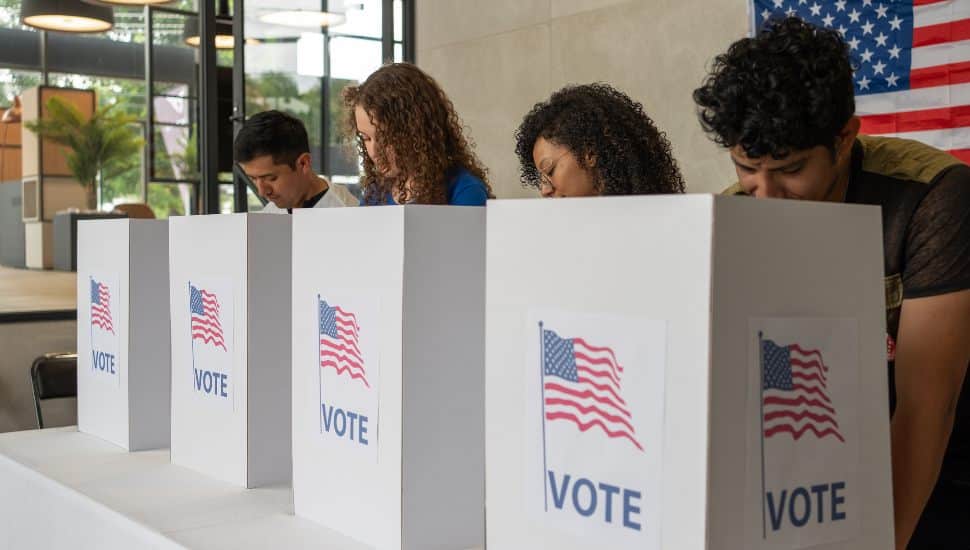 People voting behind folders.
