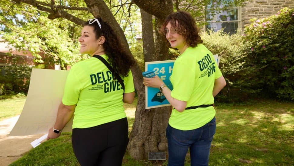 Staff members put up signs from last year's Delco Gives event.