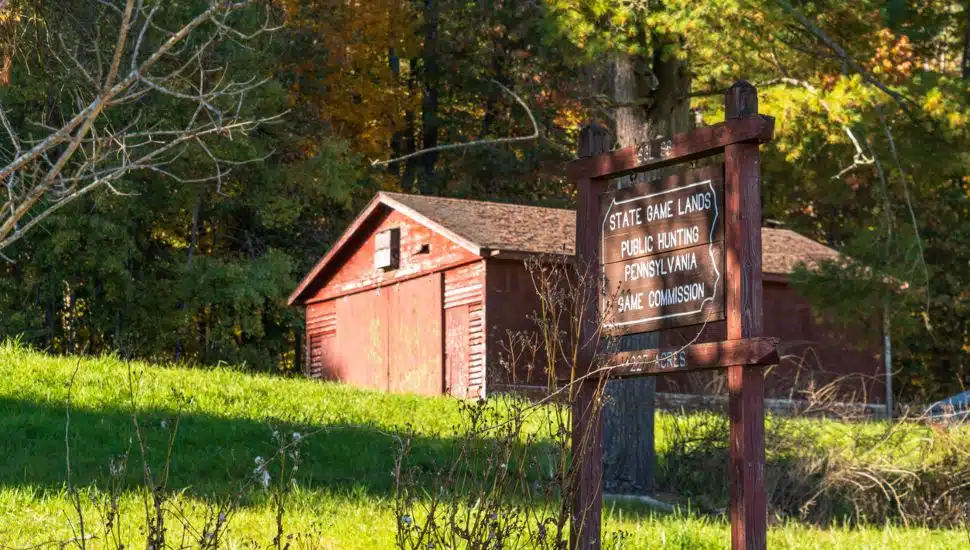 A building on top of a hill in Deerfield Township with a Pennsylvania Game Commission Game Land 86 wooden sign on a sunny fall day.