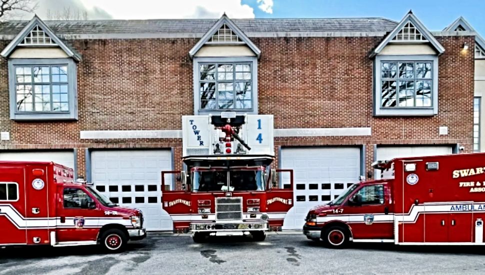 The outside of the Swarthmore Fire and Protective Association firehouse with three fire vehicles parked otside.