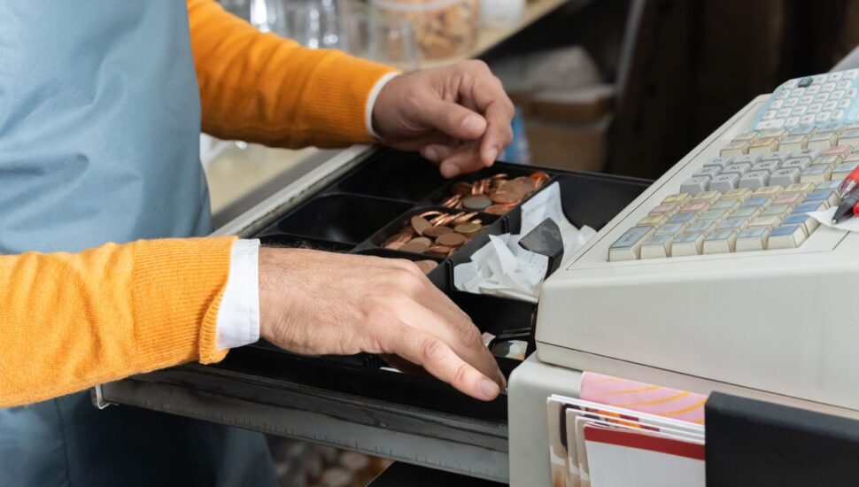 A cashier makes change at a cash register.
