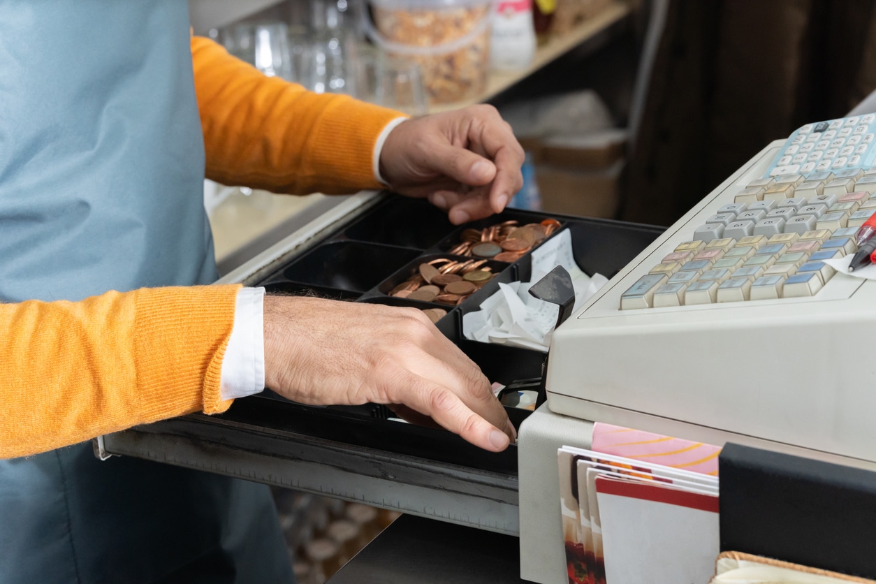 A cashier makes change at a cash register.