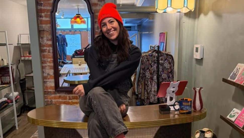 Molly Ferguson sitting on counter in her shop.