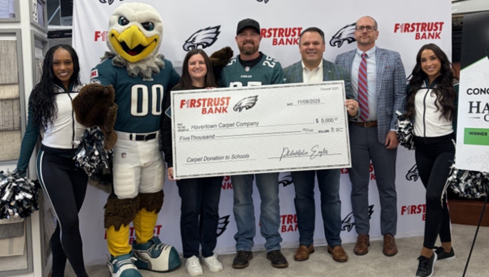Check donation to small business with Eagles cheerleaders and mascot.