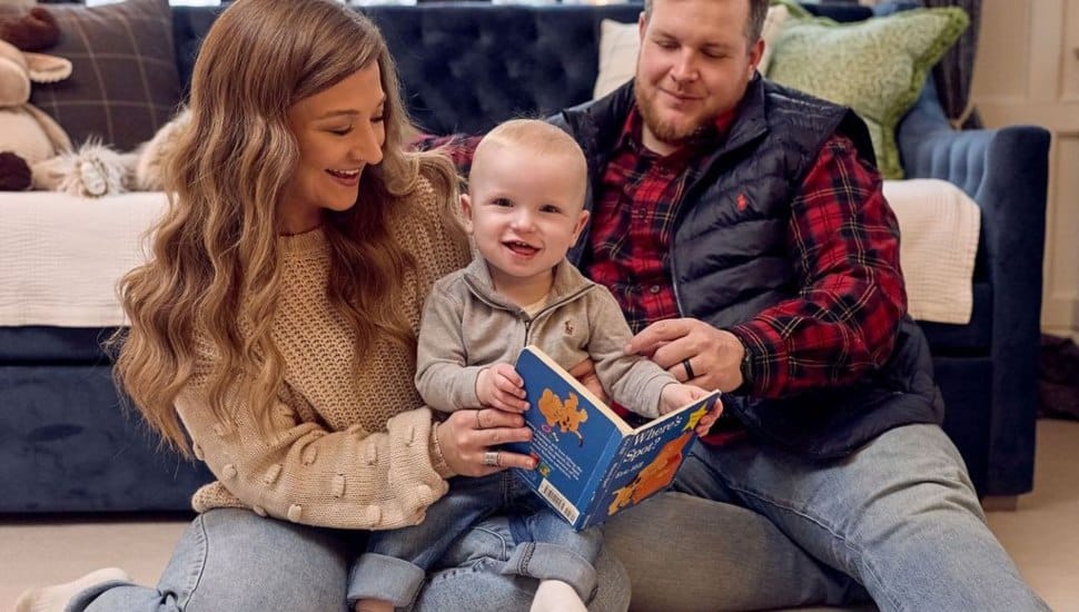 KJ Muldoon enjoys some book time with his parents, Nicole and Kyle.