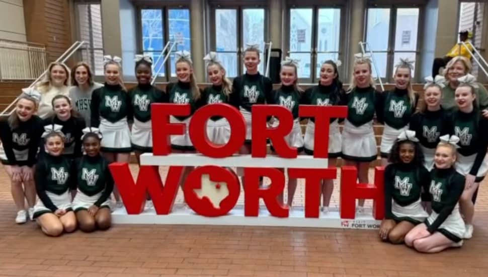 The Methacton High School cheer team gather around a Forth Worth sign.