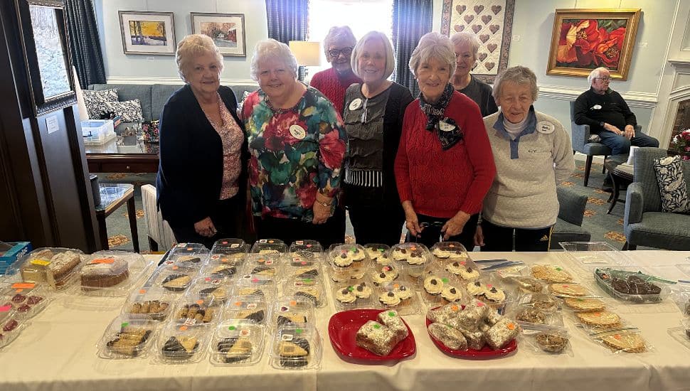 Freedom Village residents stand behind some of the items available at their fundraising bake sale.