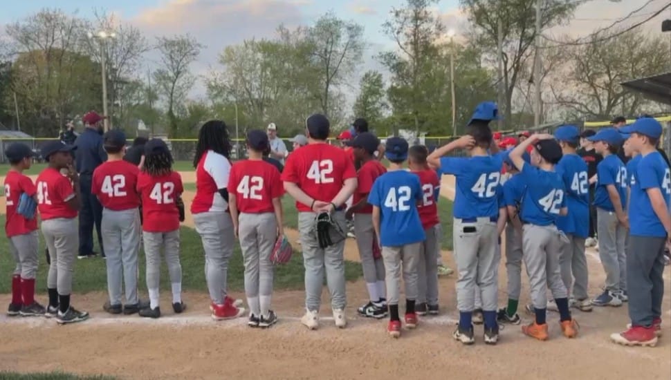 Members of the Drexel Hill Little League line up during a respectful ceremony honoring the legacy of Jackie Robinson and the Negro Leagues.