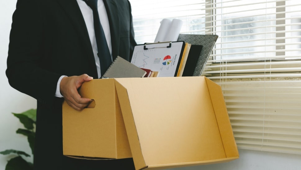 Employee carrying out box of belongings.