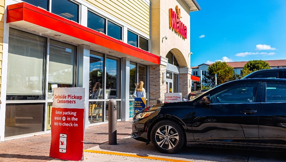Wawa store exterior with sign for curbside pickup
