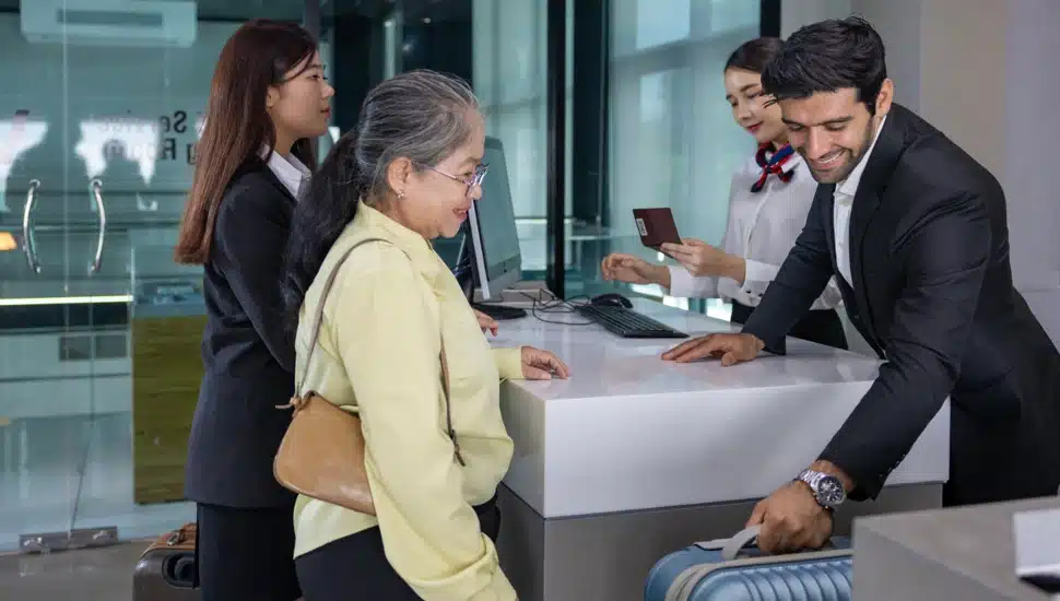 A passenger checks her luggage at the airline check-in counter.