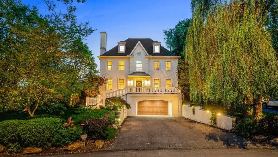 Large, white French Colonial surrounded by trees at 616 Brookside Ave in Wayne.