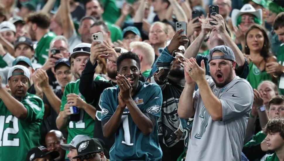 Eagles fans cheering in the stands at Lincoln Financial Field during a Philadelphia Eagles game.