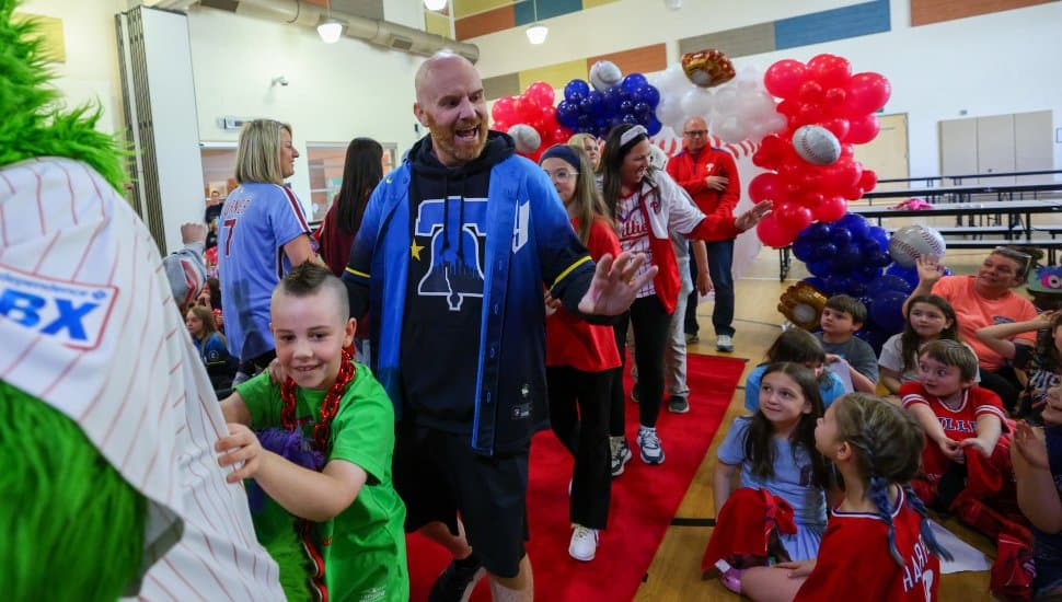 Scott Messick walking into the Boothwyn Elementary School gym with the Phillie Phanatic.
