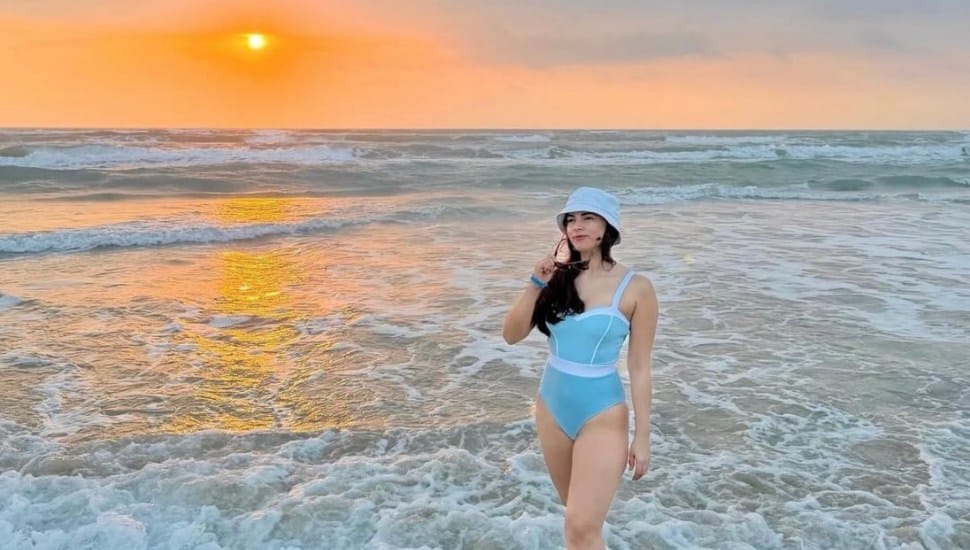 Sweat2Swim swimwear model on the beach at sunset.