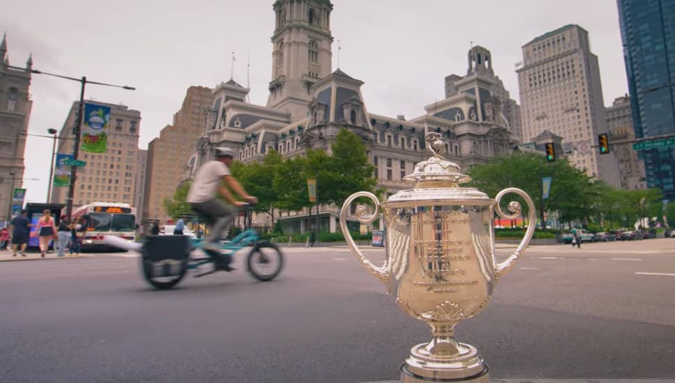The Wanamaker Trophy placed on a corner in Philadelphia, with City Hall in the background.