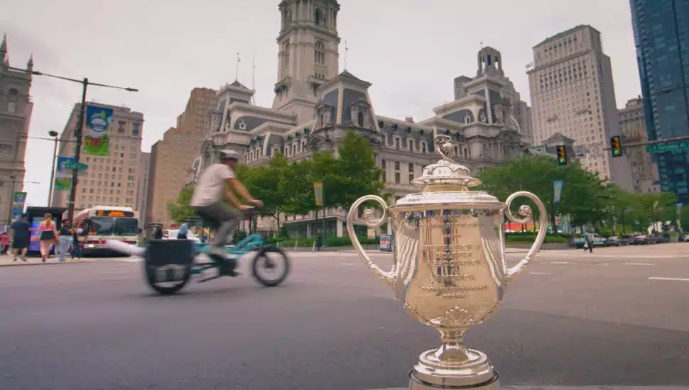 The Wanamaker Trophy placed on a corner in Philadelphia, with City Hall in the background.