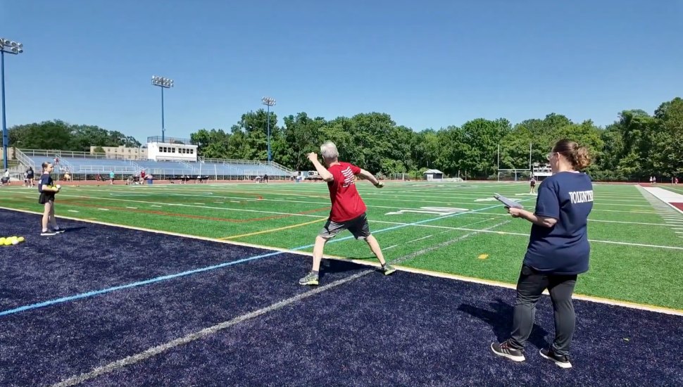 A senior tosses a softball at the Delaware County Senior Games at Cardinal O'Hara's football field.