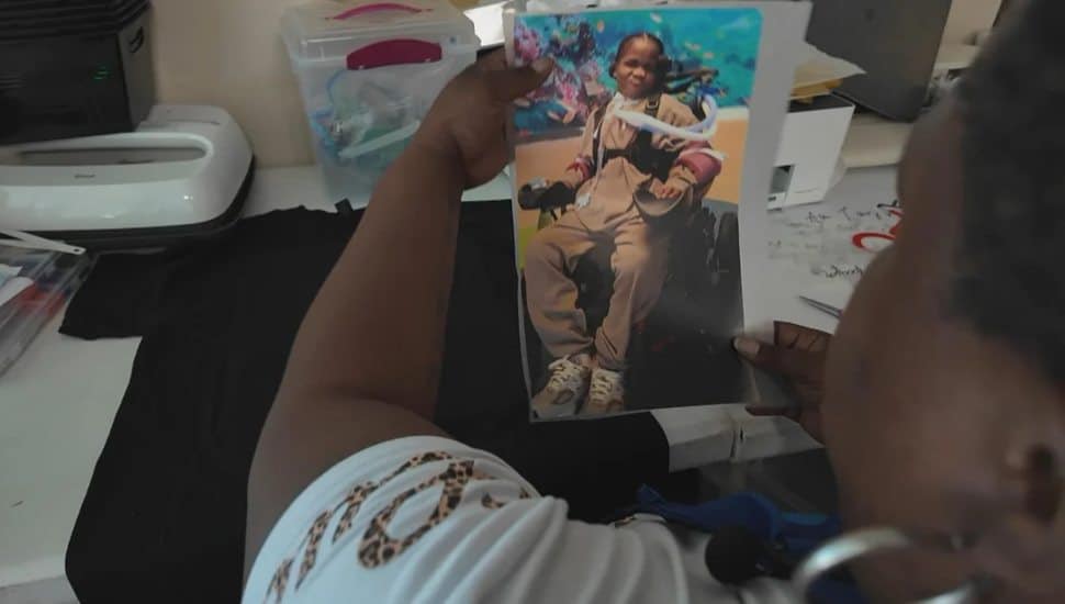 Anita Carrington looking at a picture of Ny'Leek Ellison.