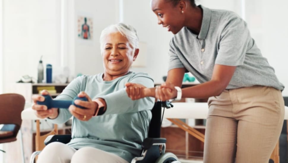 A Freedom Village at Brandywine staff member works on an exercise with a resident.
