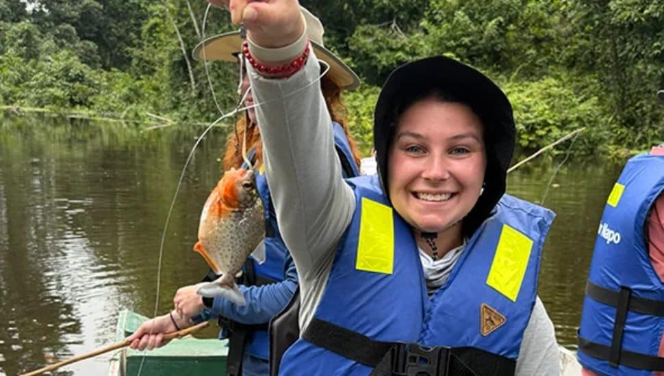 Hannah Singer holds up the piranha she caught.