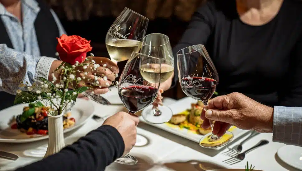 People at La Locanda Ristorante, clinking wine classes over dinner.