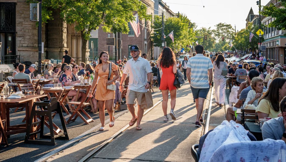 People dining outside and walking along State Street in Media.