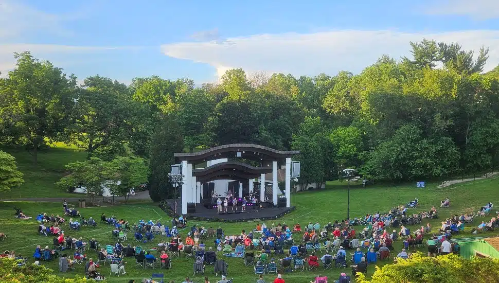 Rose Tree Park's amphitheater during a concert, with people watching from the grass.