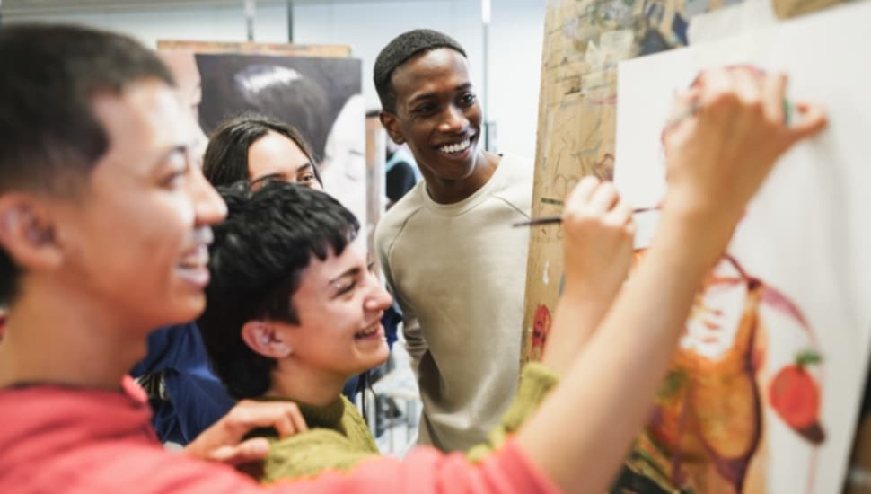 A group of students work on a painting.